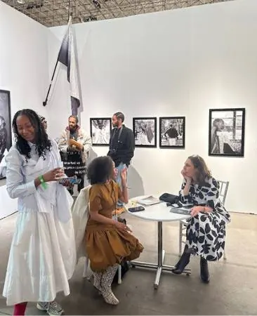 Guests talking at a table in Blanc Art Gallery among framed black-and-white photographs