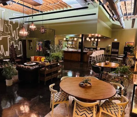 Parkway Social’s lounge with a round wooden table, bar and pendant lights